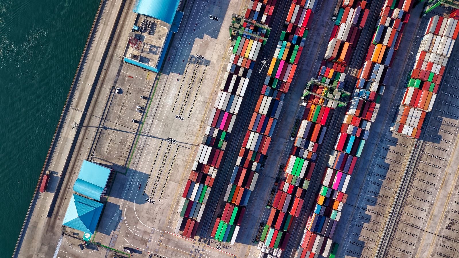 Aerial view of shipping containers stacked in a port yard